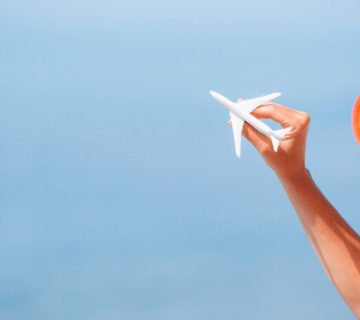 mujer-sosteniendo-avion-miniatura-con-la-mano