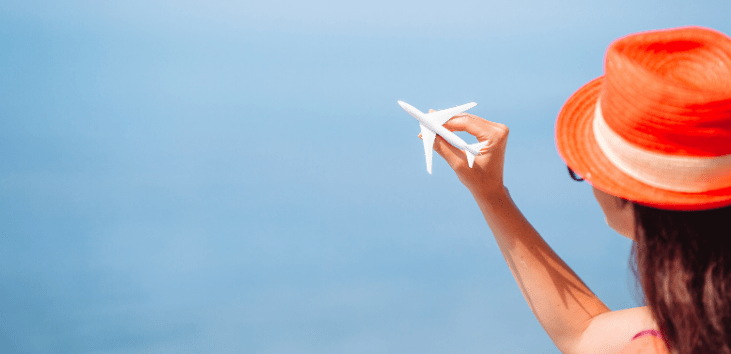 mujer-sosteniendo-avion-miniatura-con-la-mano