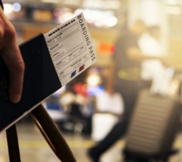 mano-sosteniendo-tiquetes-de-avion